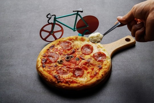プロテイン入りの粉チーズをかけて食べるピザ。自転車ピザカッターで切り分けます