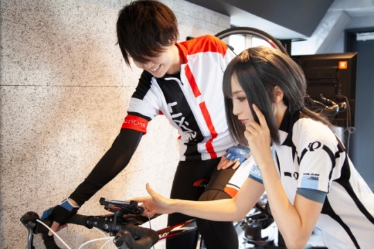 サイクルジャージ着用の女性スタッフが使用方法をレクチャーします。